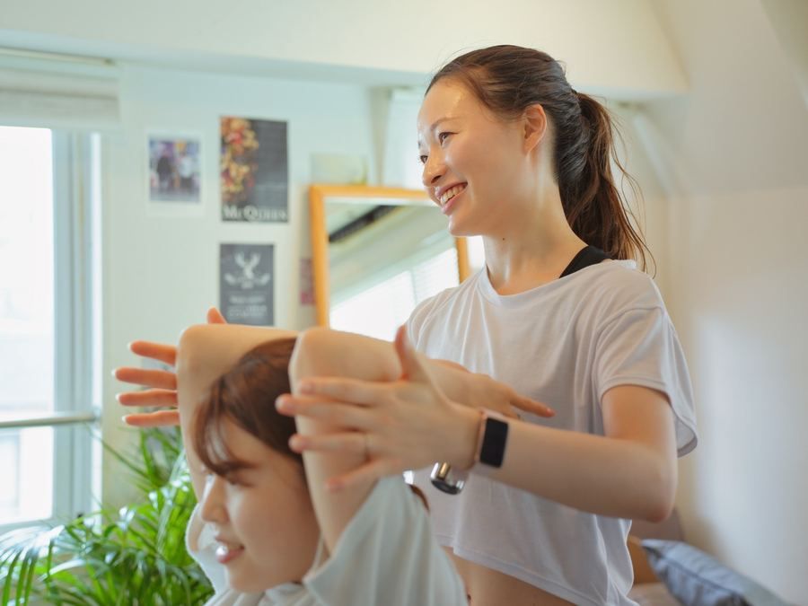 腕を上げるエクササイズを指導する様子