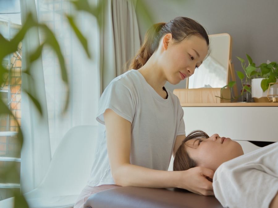 首まわりに手を添える施術の様子